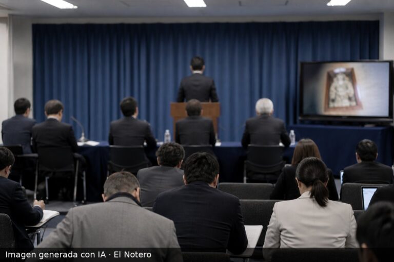 Sala de prensa con funcionarios de espaldas y un orador en un atril, en un clima institucional y sobrio.