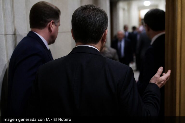 Pasillo del Parlamento con una figura de espaldas hablando con otros funcionarios, en una escena tensa y desenfocada.