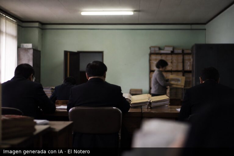 Sala de oficina administrativa con funcionarios de espaldas, carpetas y archivos sobre una mesa, en una escena de investigación documental.