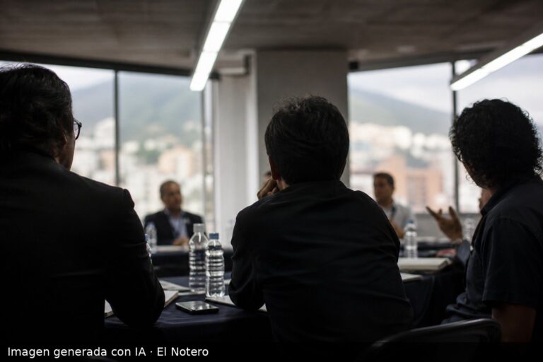 Reunión en una sala en Caracas, con varias personas sentadas alrededor de una mesa, vistas de espaldas y sin rostros visibles, en un clima sobrio de encuentro y escucha.