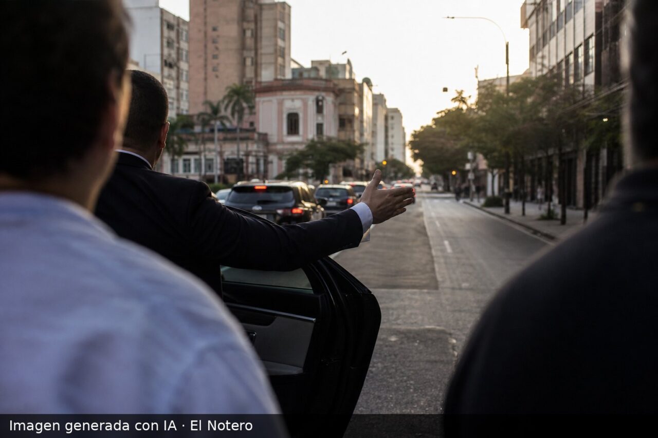 Una caravana de campaña vista desde atrás en una calle de Asunción, con varias personas desenfocadas y una figura recortada al hombro junto a un auto.