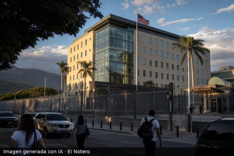 Vista exterior de la embajada de Estados Unidos en Caracas, detrás de una reja de seguridad y con peatones desenfocados al frente.